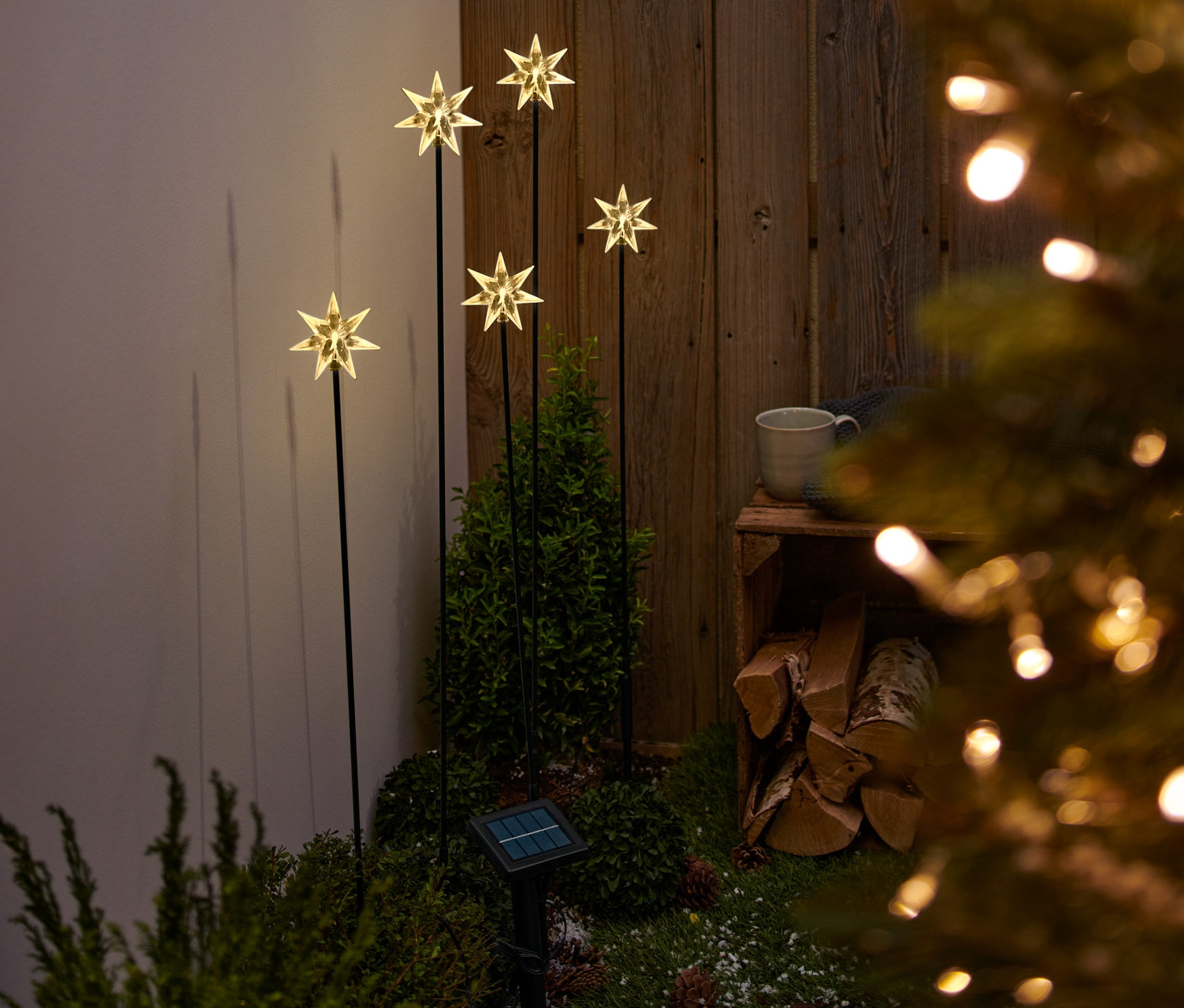 Päť solárnych zapichovacích svietidiel s hviezdami v záhrade.