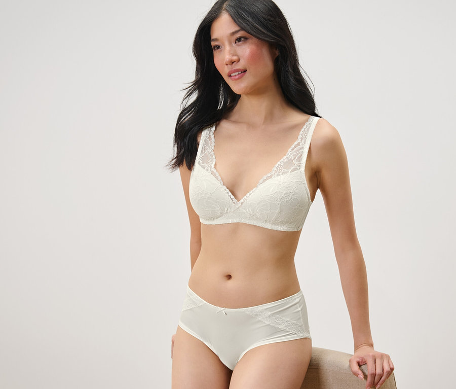 Žena pózuje v krémovej čipkovanej podprsenke a nohavičkách, 2 ks, krémové.