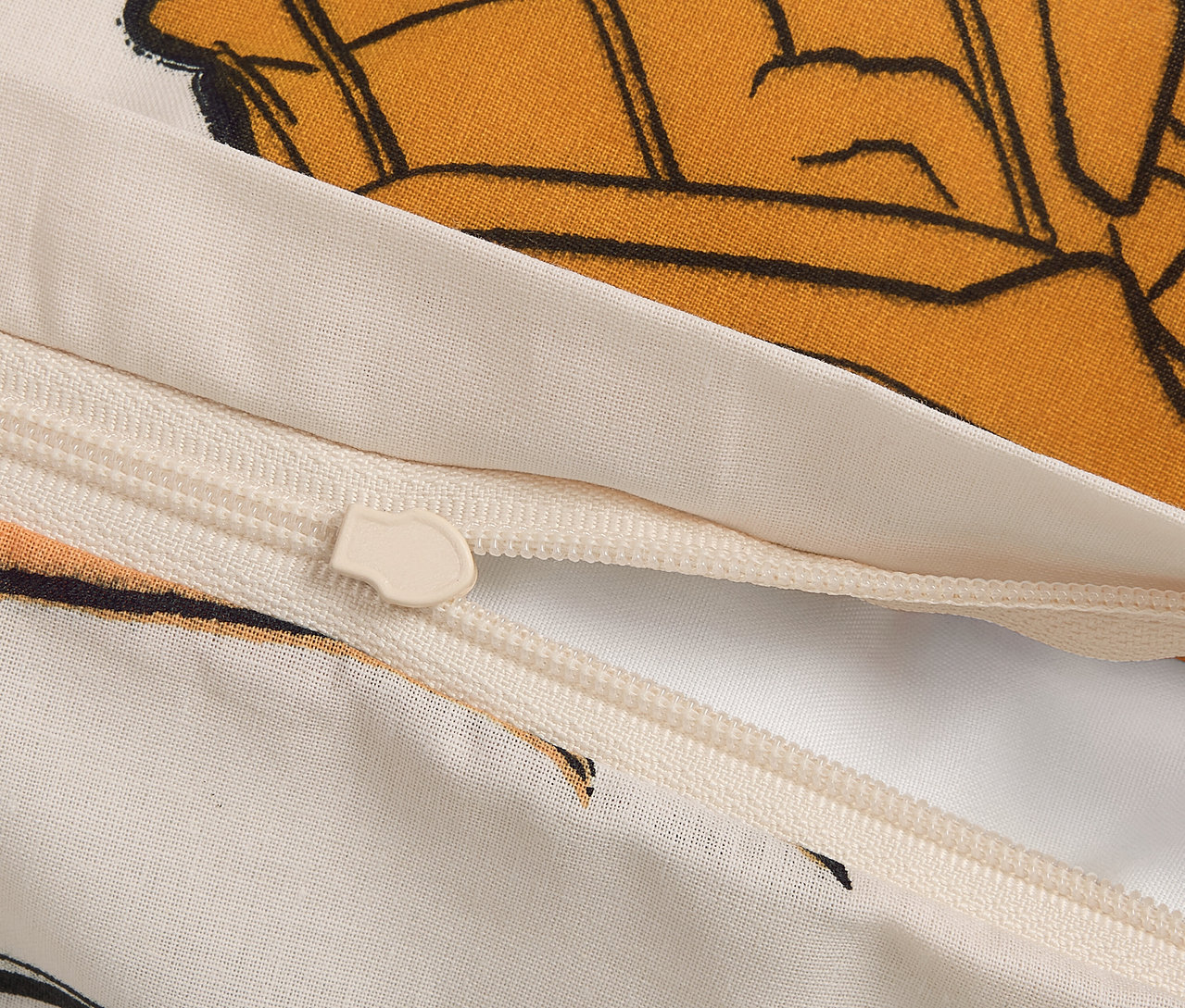 Detail zipsu na obliečke s kresleným motívom.