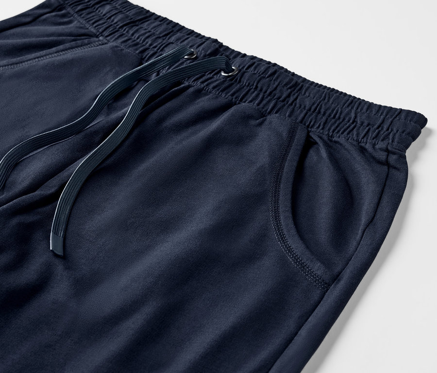Detailný záber na 3/4 teplákové nohavice tmavomodrej farby s elastickým pásom a sťahovacou šnúrkou.
