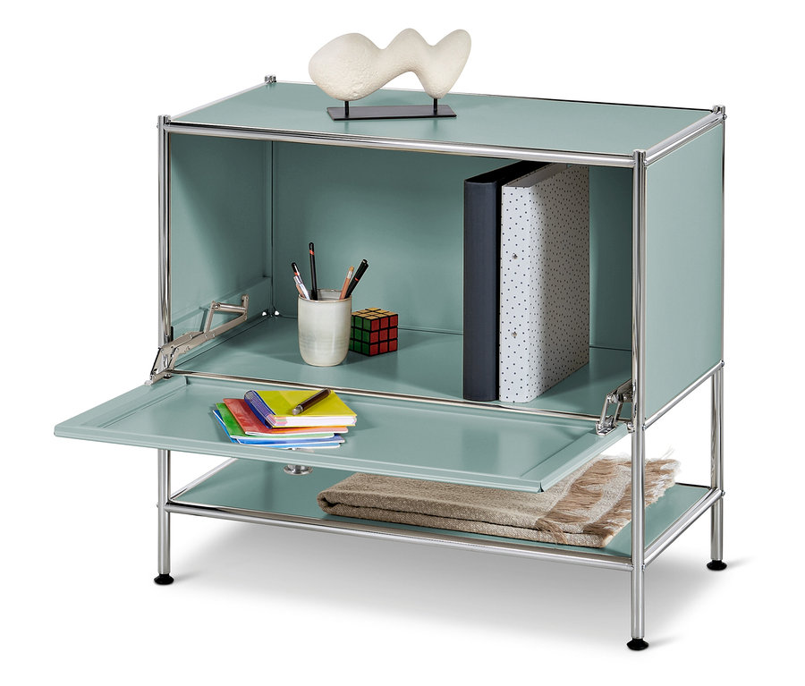 Modrozelená skrinka s otvorenými dverami a policami s knihami, pastelkami, Rubikovou kockou, poznámkovými blokmi a dekou.