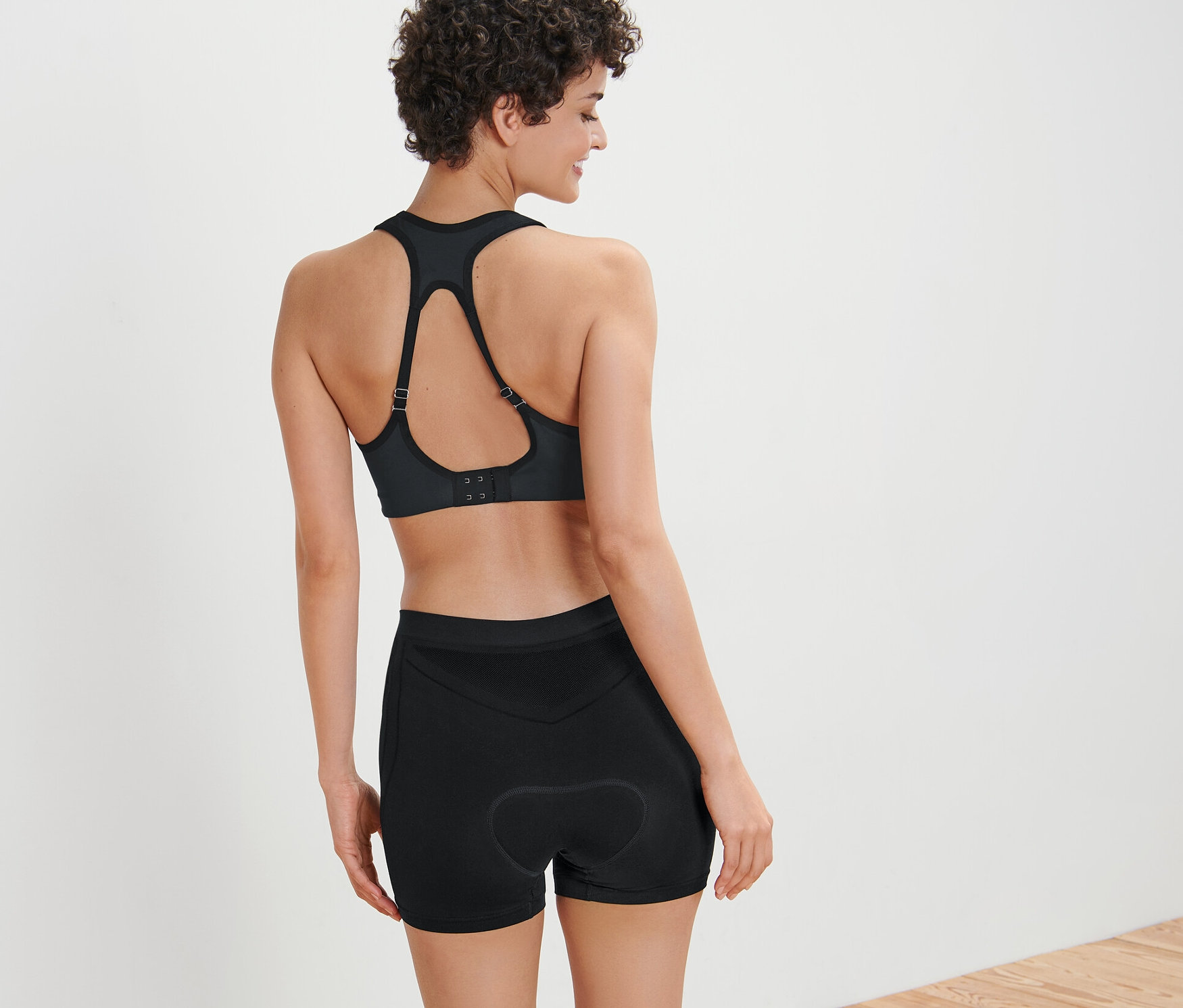 Žena má na sebe športovú podprsenku a cyklistické spodky.