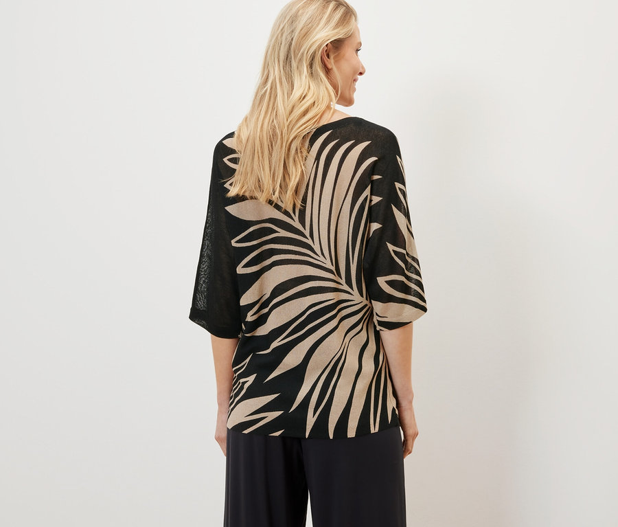 Žena má na sebe potlačený pulóver z jemného úpletu.