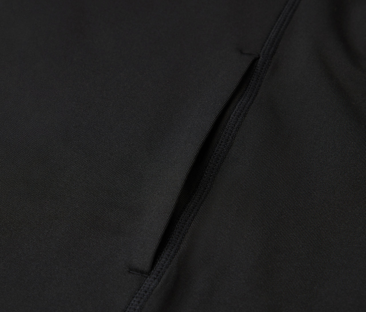 Detail čierneho športového oblečenia s vreckom.
