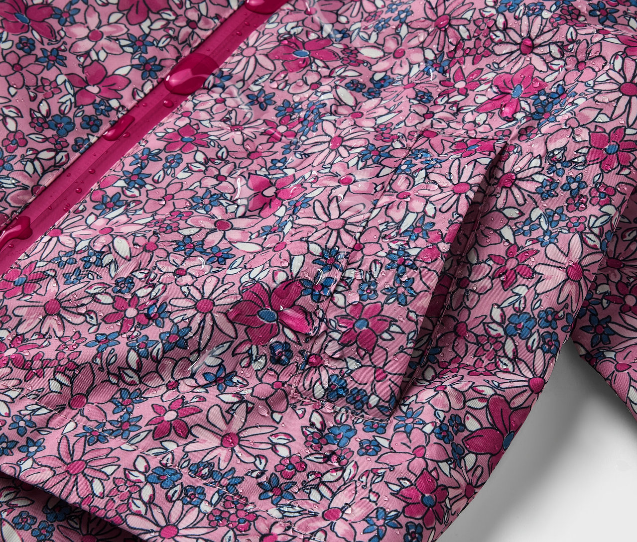 Detail detskej termo bundy do dažďa s kvetinovou potlačou.