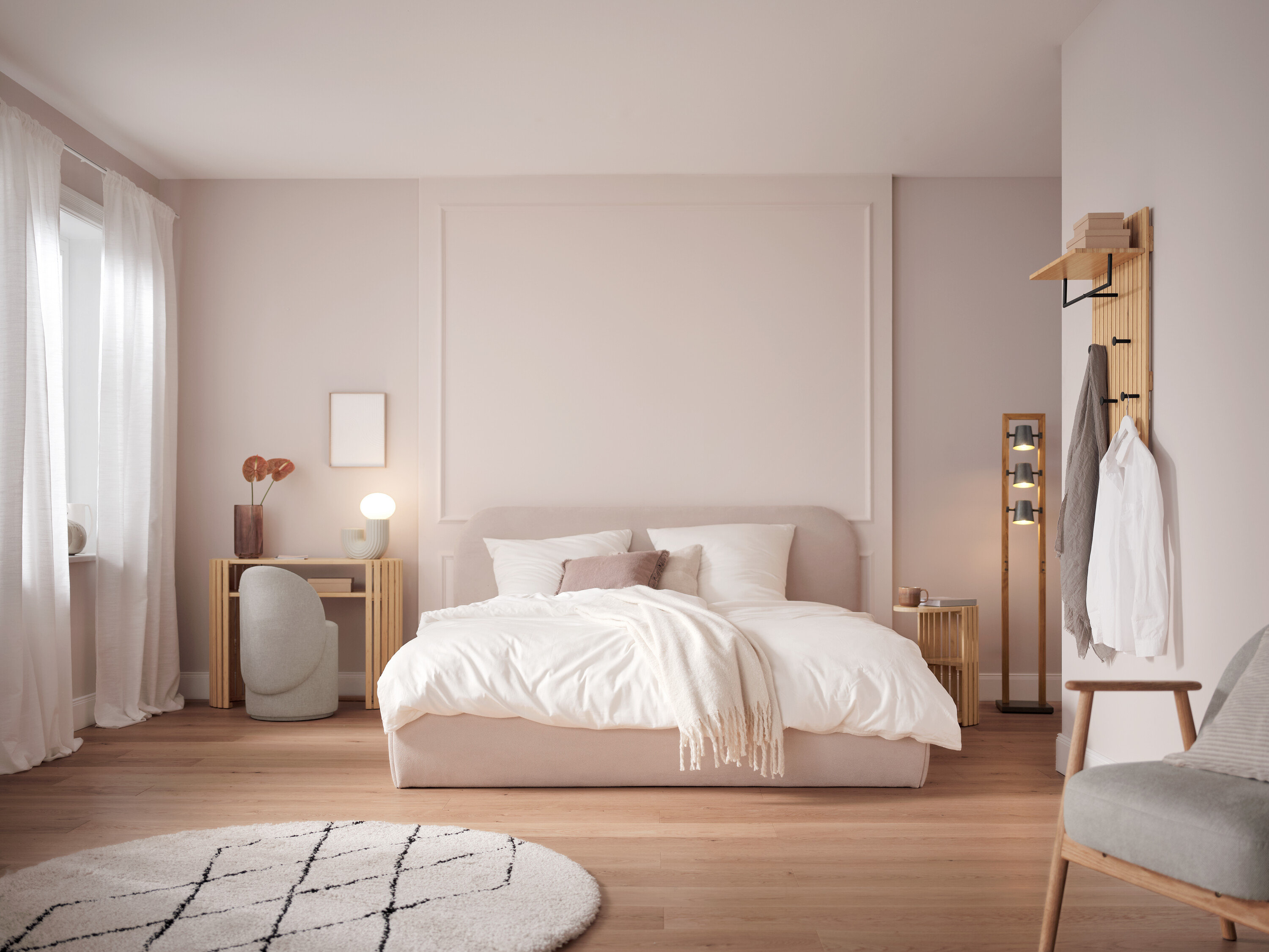 Spálňa s posteľou s bielymi obliečkami, stolom, stoličkou a dekoráciami.