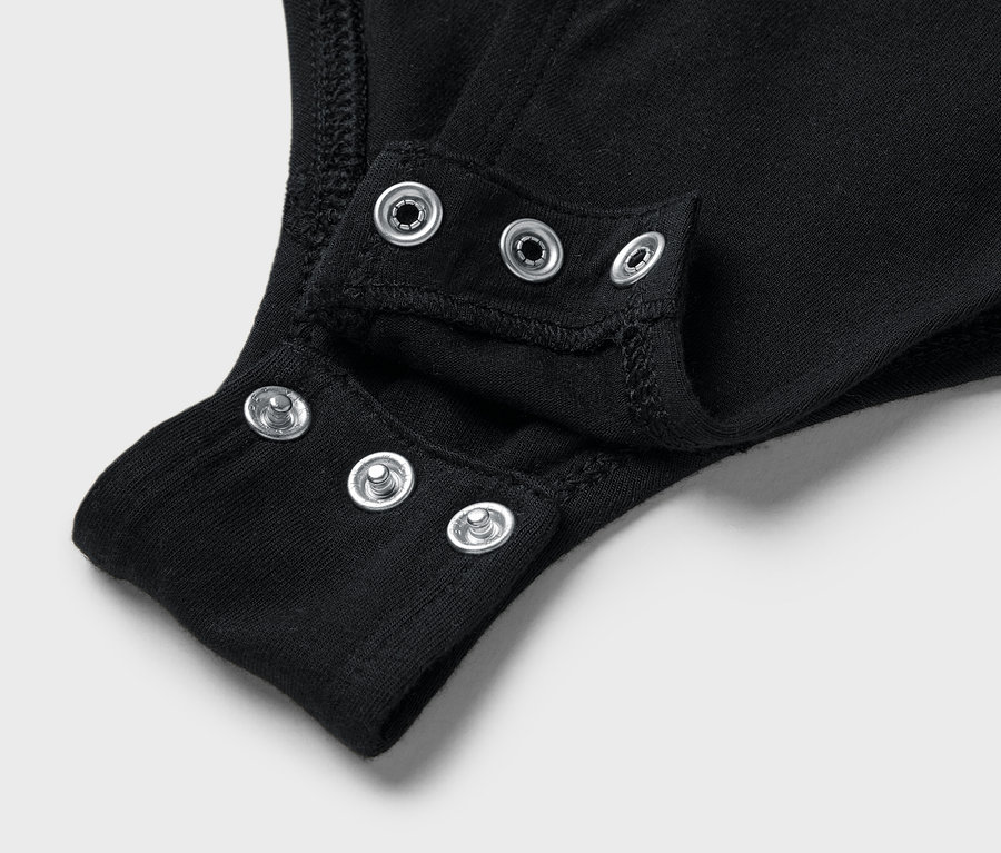 Detail čierneho body s patentkami v rozkroku.