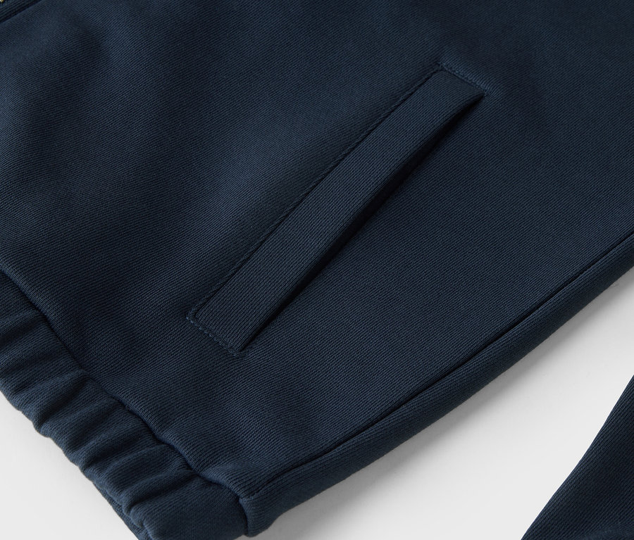 Detailný záber na tmavomodrú mikinu na zips s vreckom.