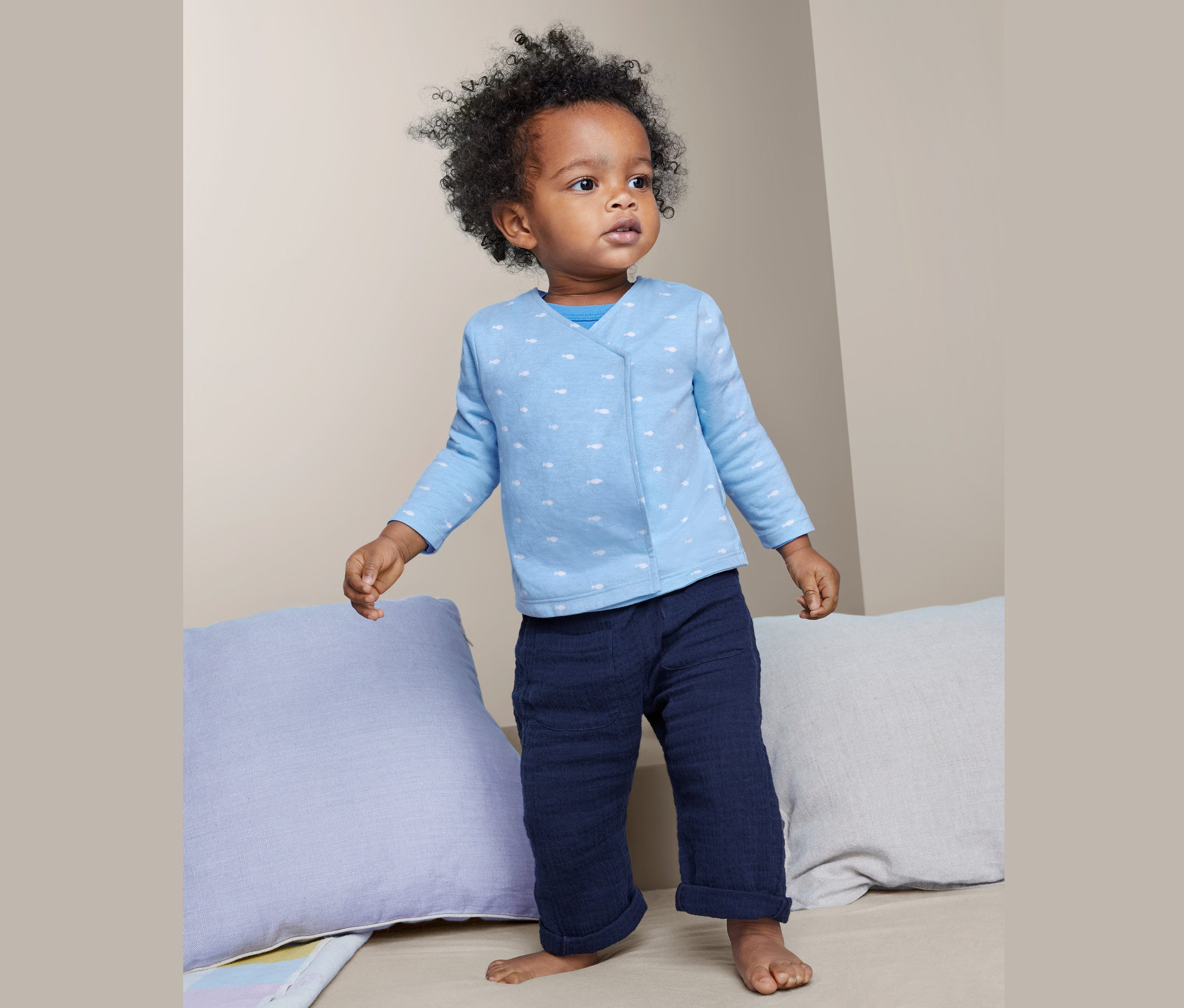 Malé dieťa stojí a má na sebe detské bavlnené zavinovacie kabátiky, 2 ks.