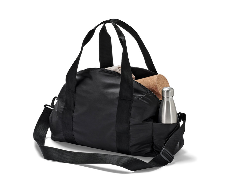 Čierna športová taška so striebornou fľašou na vodu a korkovou kockou.