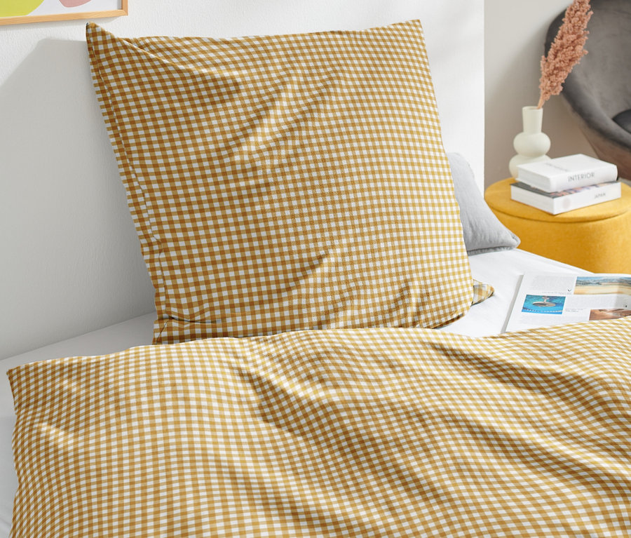 Detail bavlnenej posteľnej bielizne renforcé štandardnej veľkosti s hnedo-bielou kockovanou potlačou.