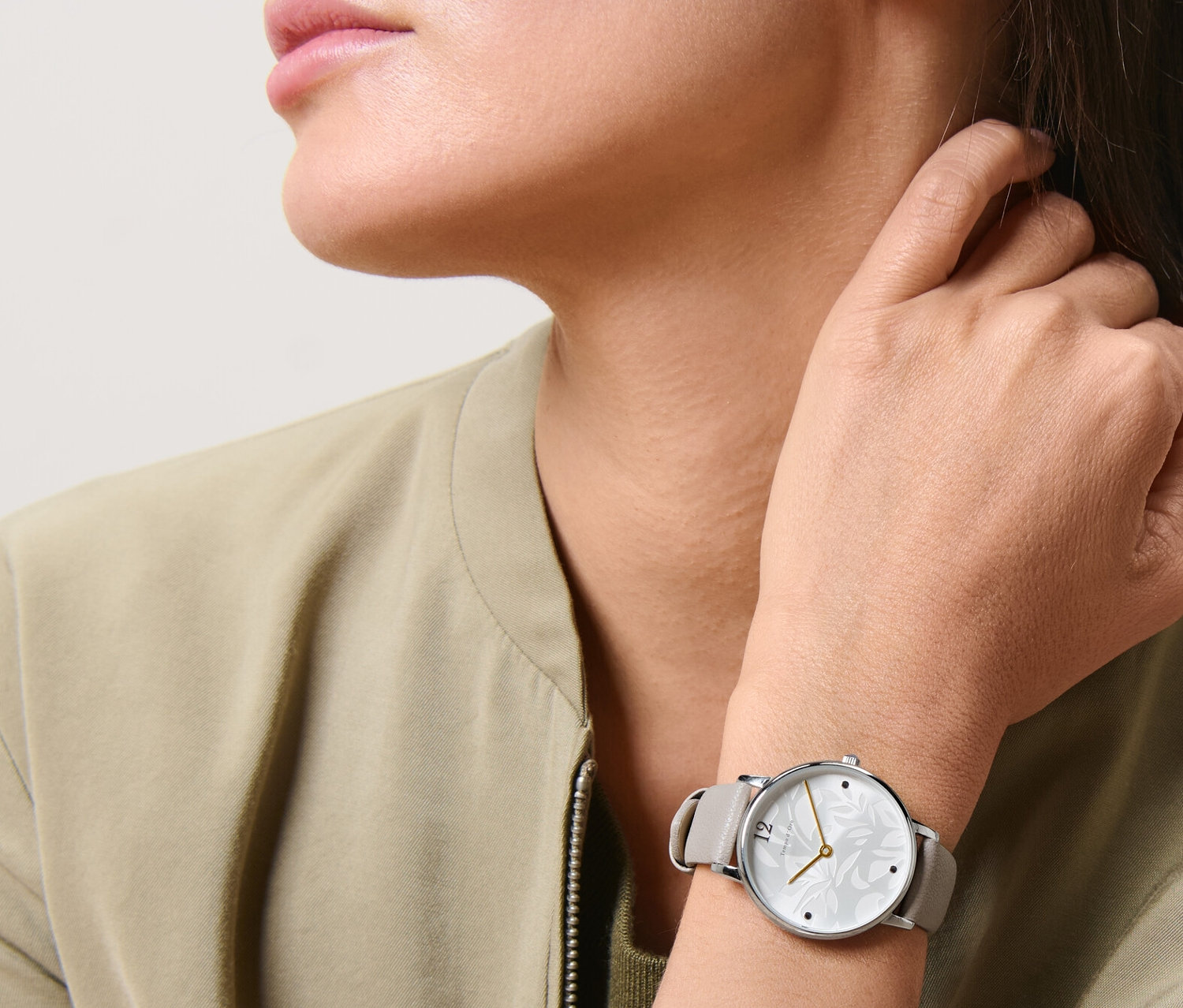 Žena nosí dámske náramkové hodinky.