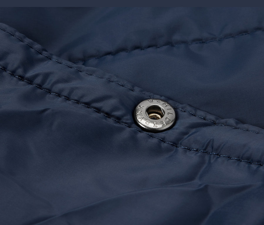 Detailný záber na tmavomodrú ultraľahkú cestovnú deku s patentom.