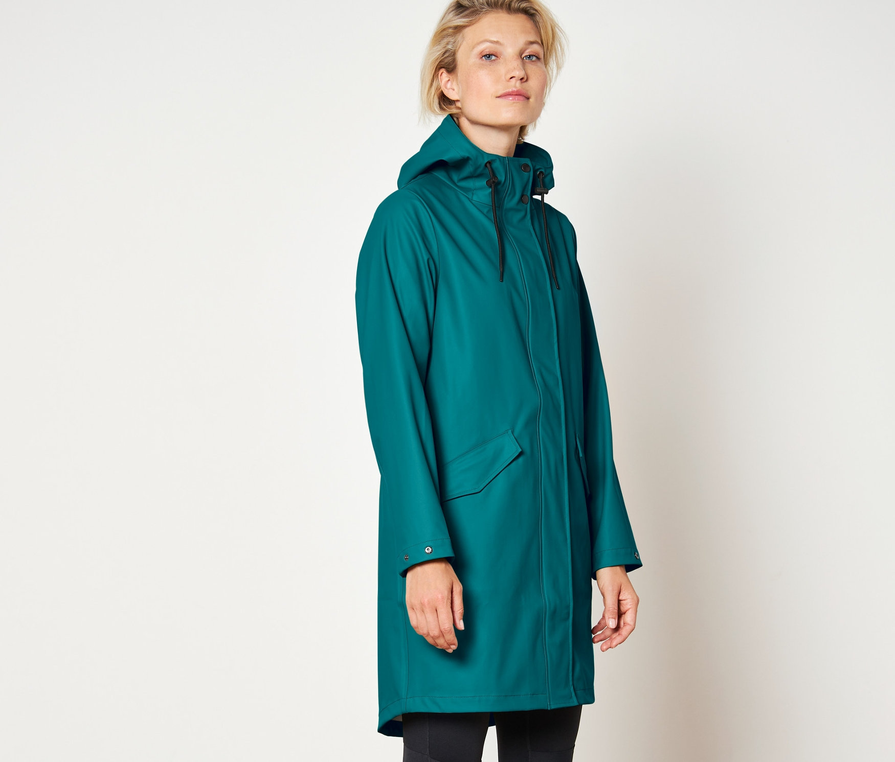 Žena má na sebe pršiplášť.