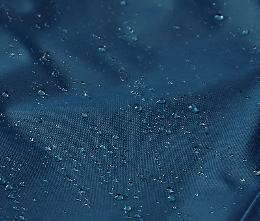 Detail detských termonohavíc do dažďa s kvapkami vody na povrchu.