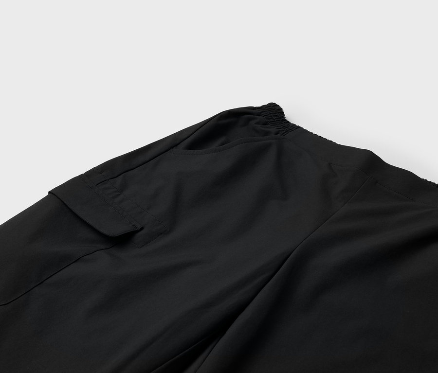 Detail čiernych nohavíc s vreckom a elastickým pásom.