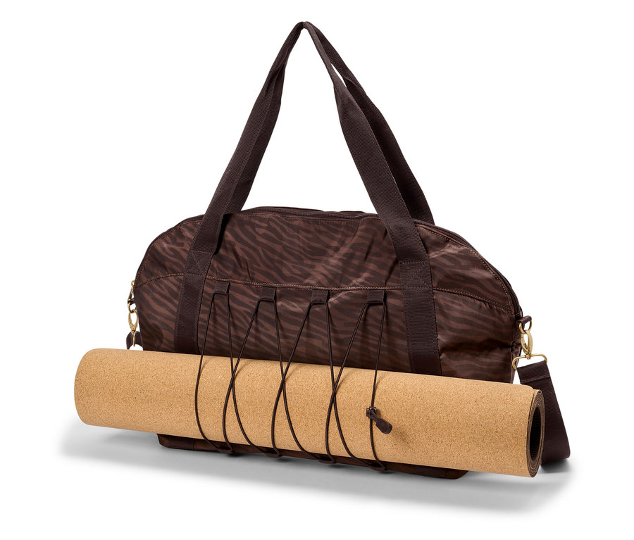 Hnedá športová taška so zebrovou potlačou drží zrolovanú korkovú podložku na jogu.
