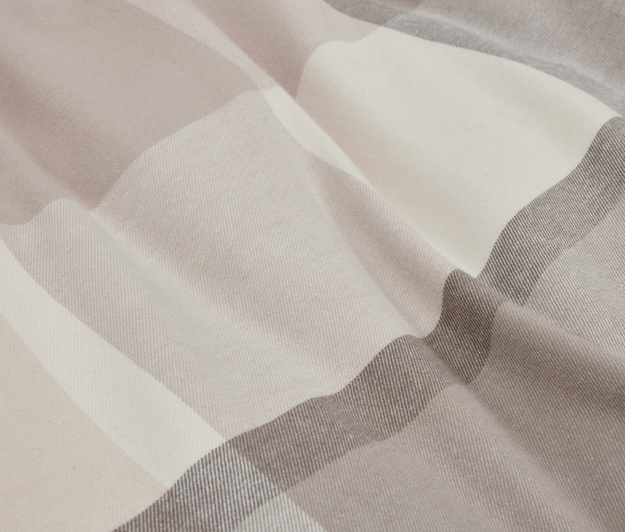 Detailný záber na látku s kockovaným vzorom v béžových a sivých tónoch.