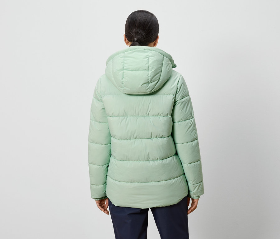 Pohľad zozadu na ženu v svetlozelenej páperovej bunde s kapucňou.