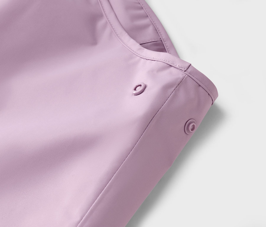 Detail fialovej pláštenky s patentkami.