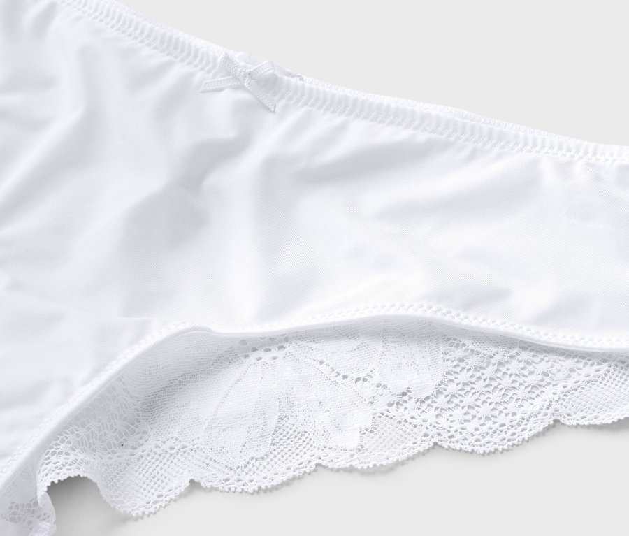 Detailný záber na bielu spodnú bielizeň s mašličkou a čipkovaným lemom.