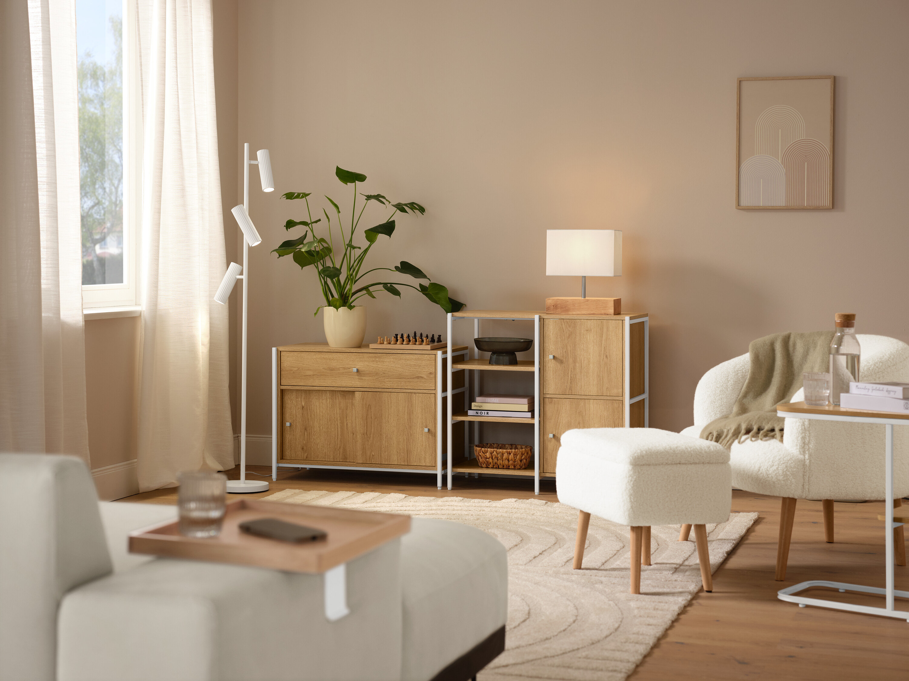 Interiérová scéna s béžovým kobercom »Cosmo«, kreslom z buklé s drevenými nožičkami a stolovou lampou s dreveným podstavcom.