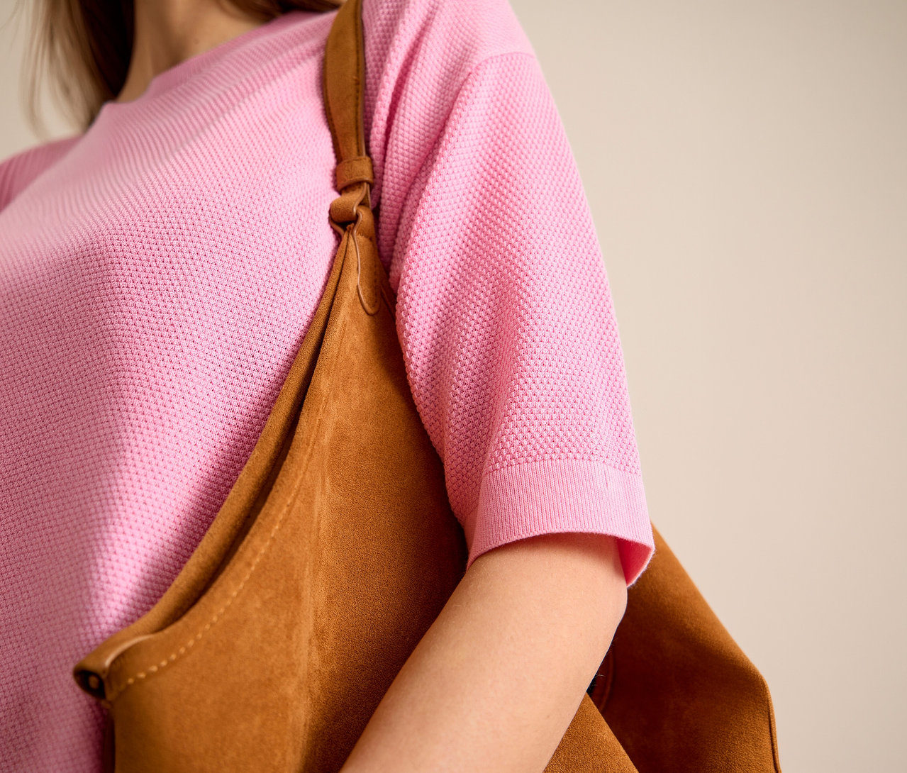 Žena má na sebe ružový pulóver s krátkym rukávom CECIL a hnedú tašku cez rameno.