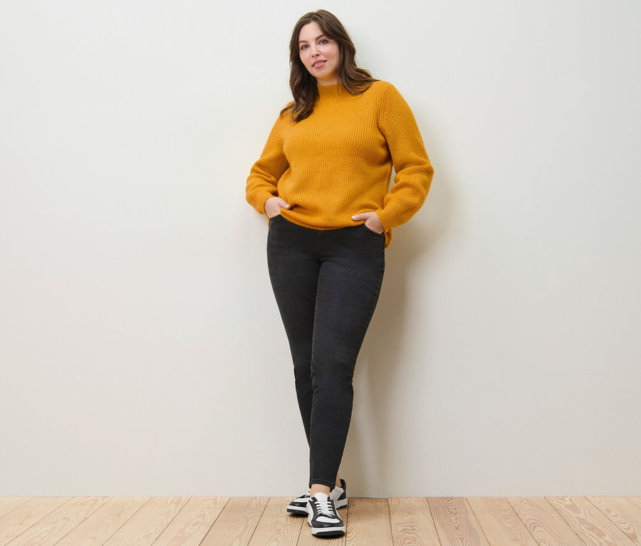 Žena pózuje v pulóvri z hrubého úpletu a slim džínsoch – Fit »Emma«.