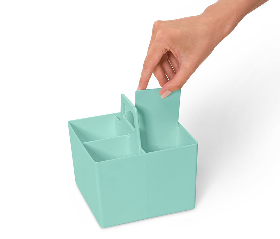 Ruka vkladá priehradku do svetlomodrého organizéra s niekoľkými priehradkami.