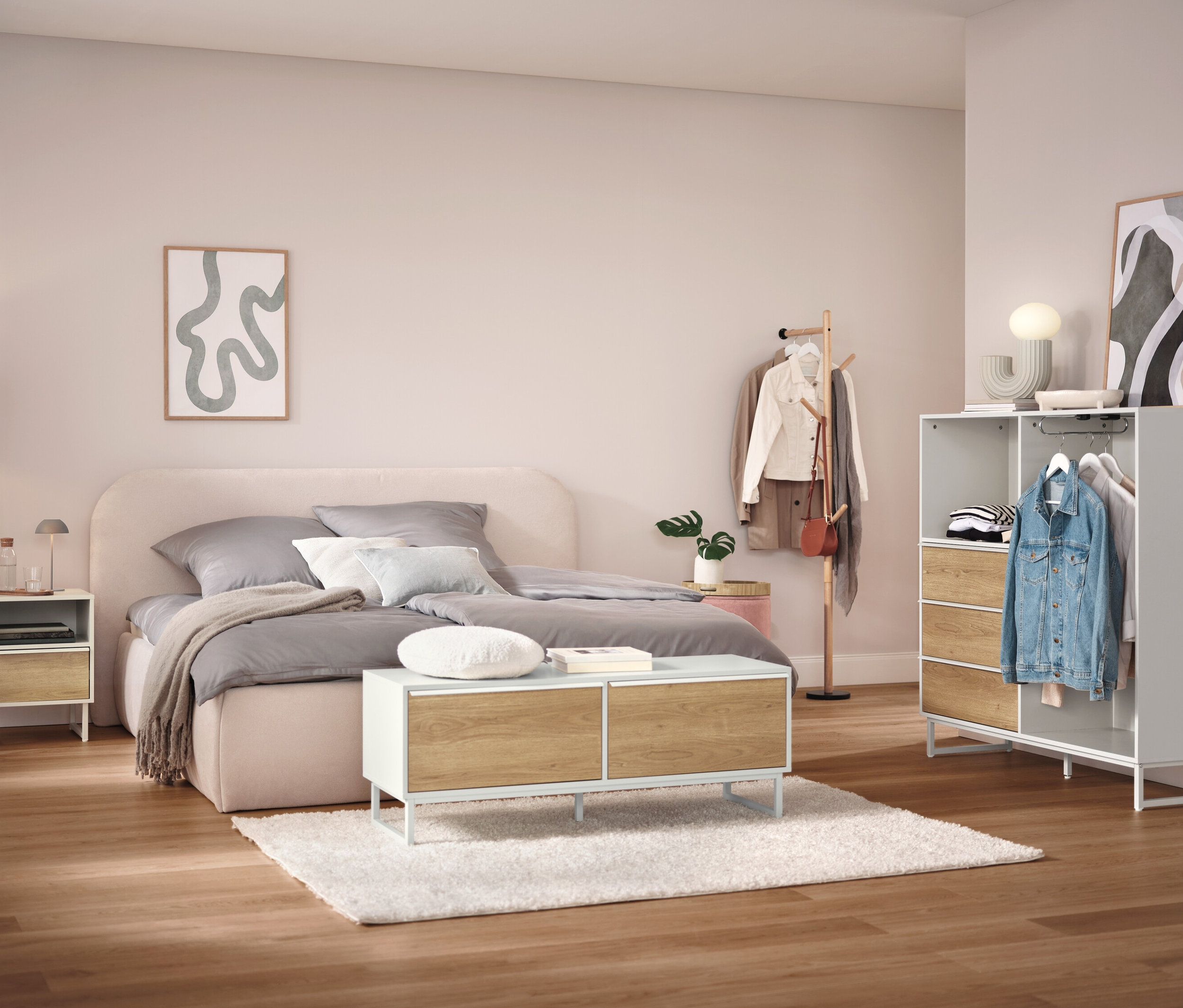 Spálňa s posteľou, nočným stolíkom, skriňou a vešiakom na oblečenie.