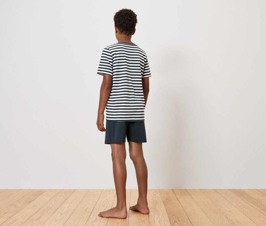 Chlapec stojí chrbtom, má na sebe pruhované tričko a šortky.