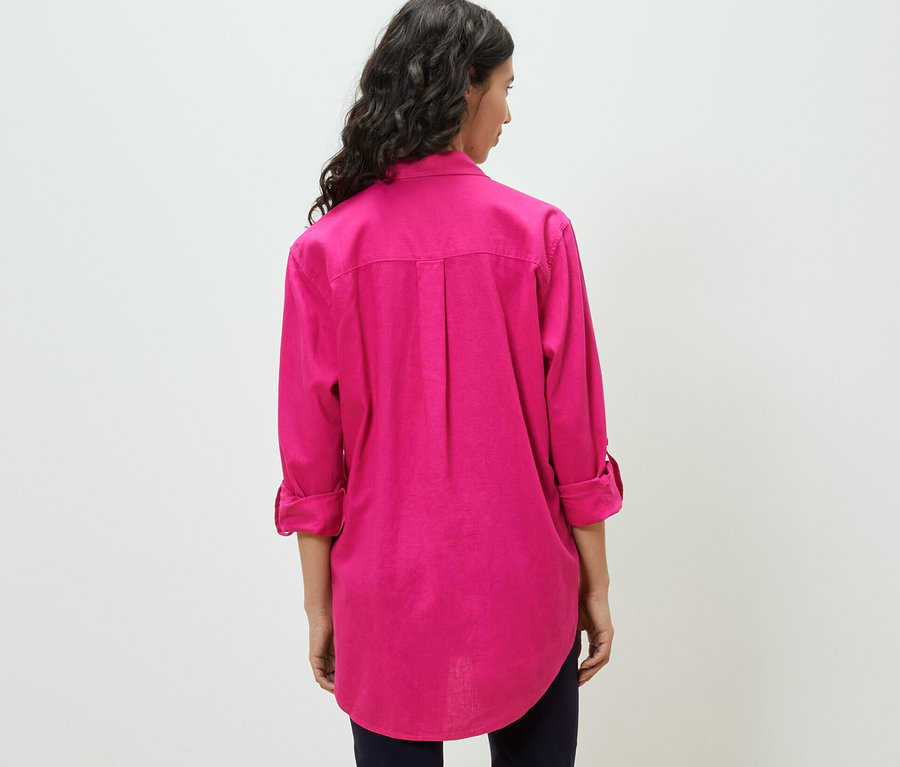 Žena má na sebe dlhú ľanovú blúzku, ružovú.