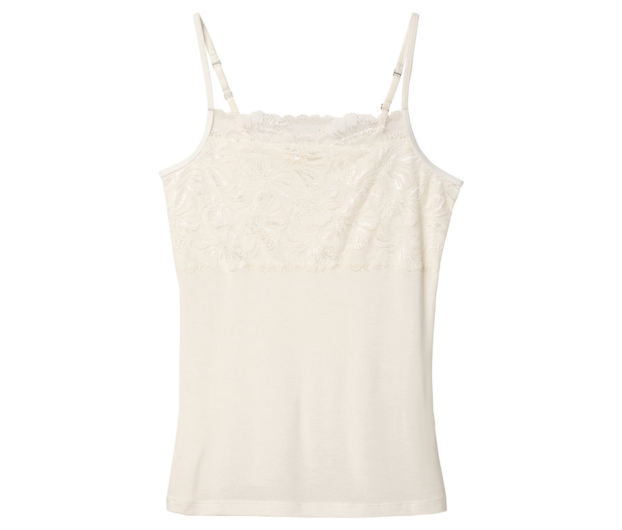 Na bielom pozadí leží krémové tielko s čipkou.