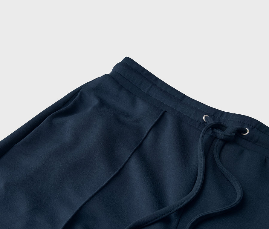 Detailný záber na tmavomodré tepláky so šnúrkou.