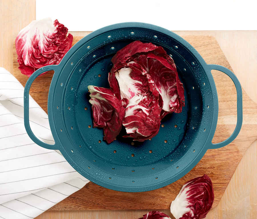 Červená kapusta v priestorovo úspornom silikónovom sitku na drevenej doske.