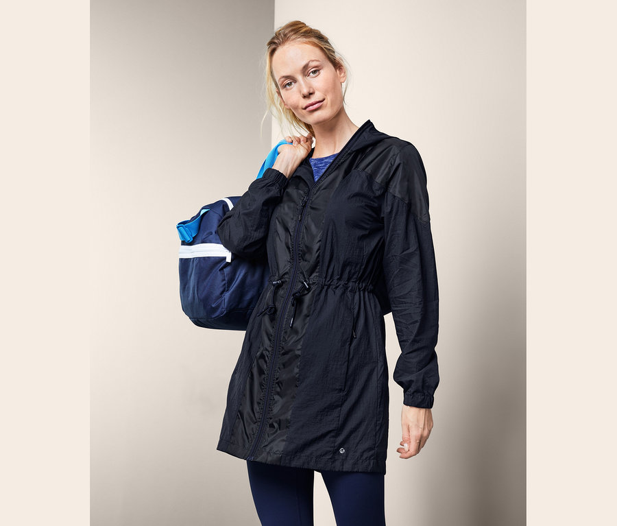 Blondínka má cez rameno športovú tašku a na sebe čiernu funkčnú bundu.