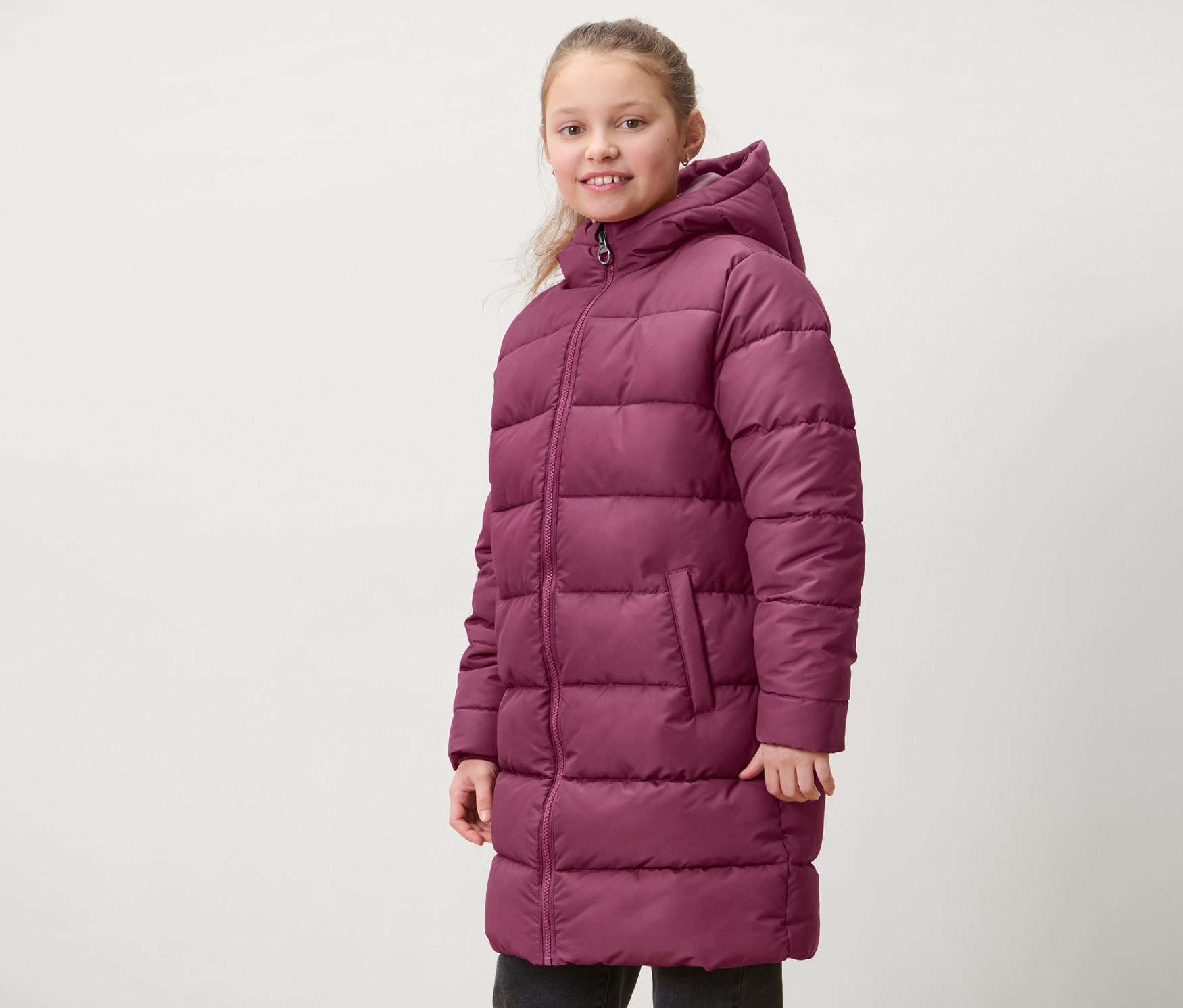 Dievča má na sebe červenofialový detský termokabát.
