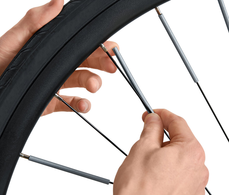 Ruky montujú 36 odraziek na špice bicykla.