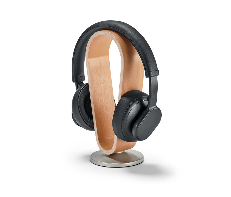 Čierne slúchadlá na drevenom stojane na slúchadlá.