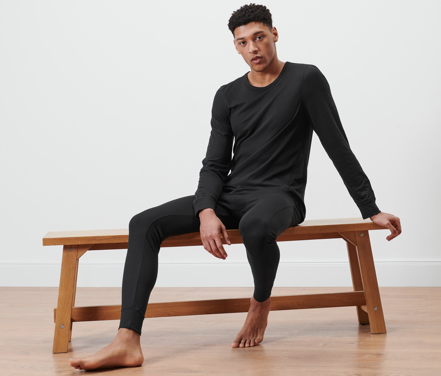 Muž sedí na lavici a má na sebe funkčné termobielizeň.