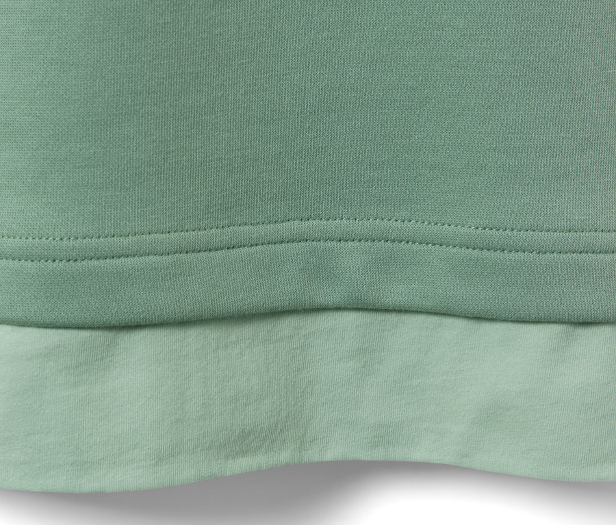 Detail svetlozeleného fitness trička s dlhými rukávmi Oversized.