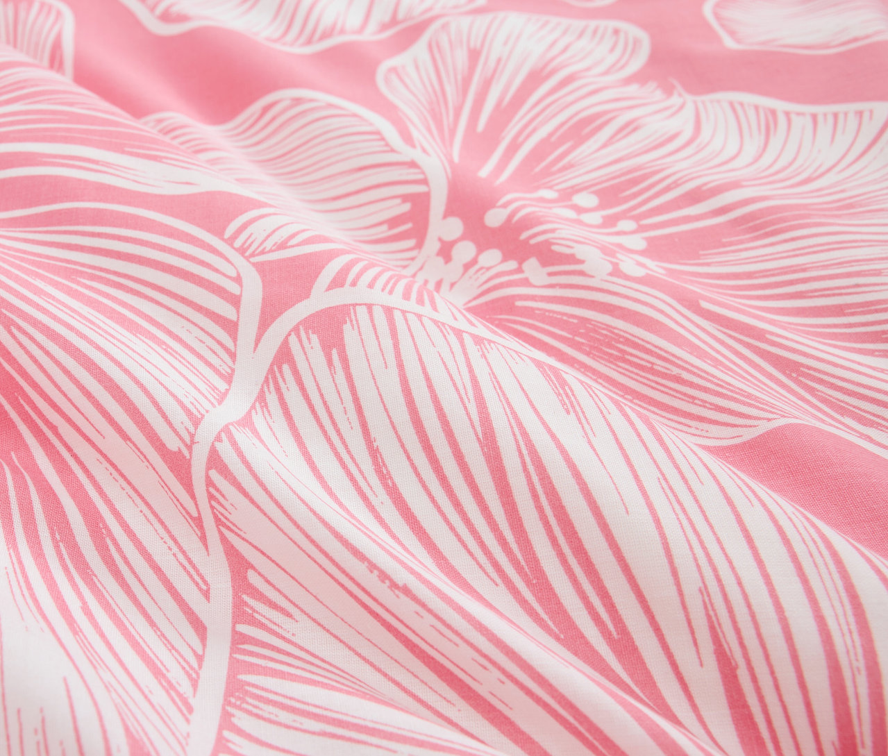 Detail ružovej látky s bielym kvetinovým vzorom.