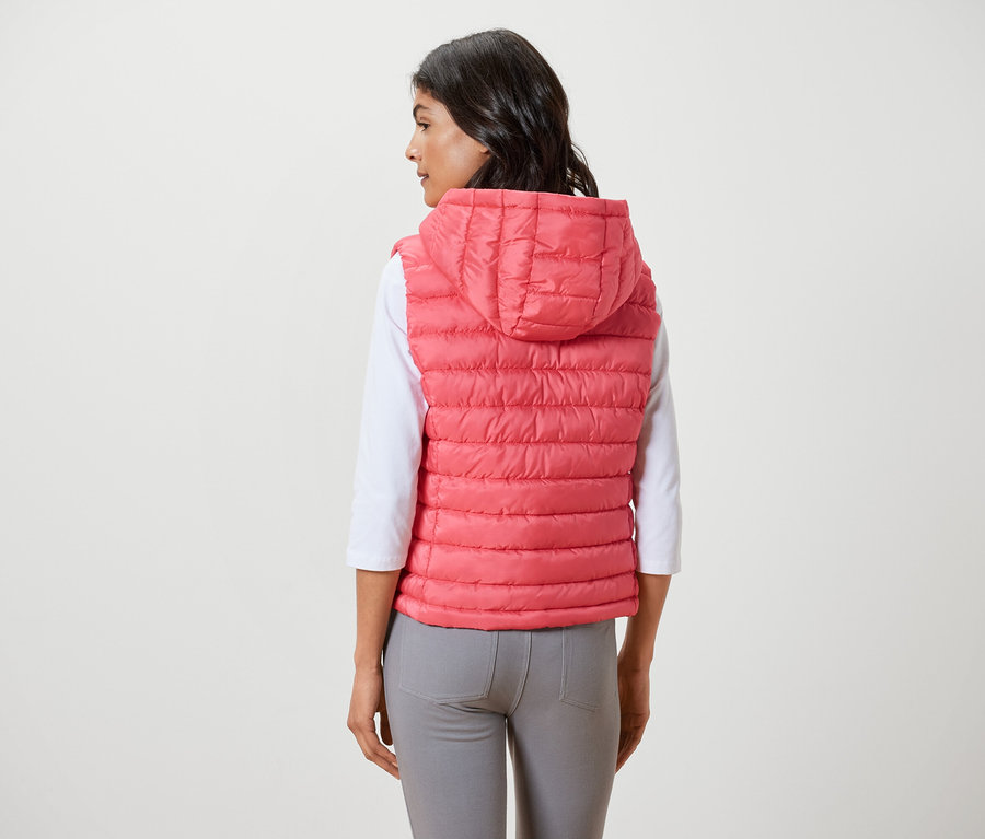 Žena má na sebe prešívanú vestu s kapucňou.