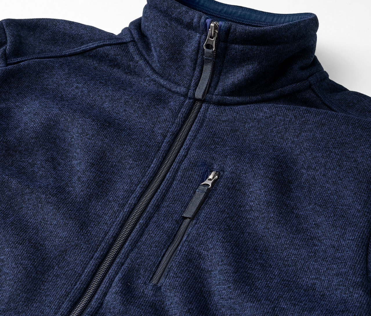 Detail modrej bundy z pleteného flaušu so zipsom.