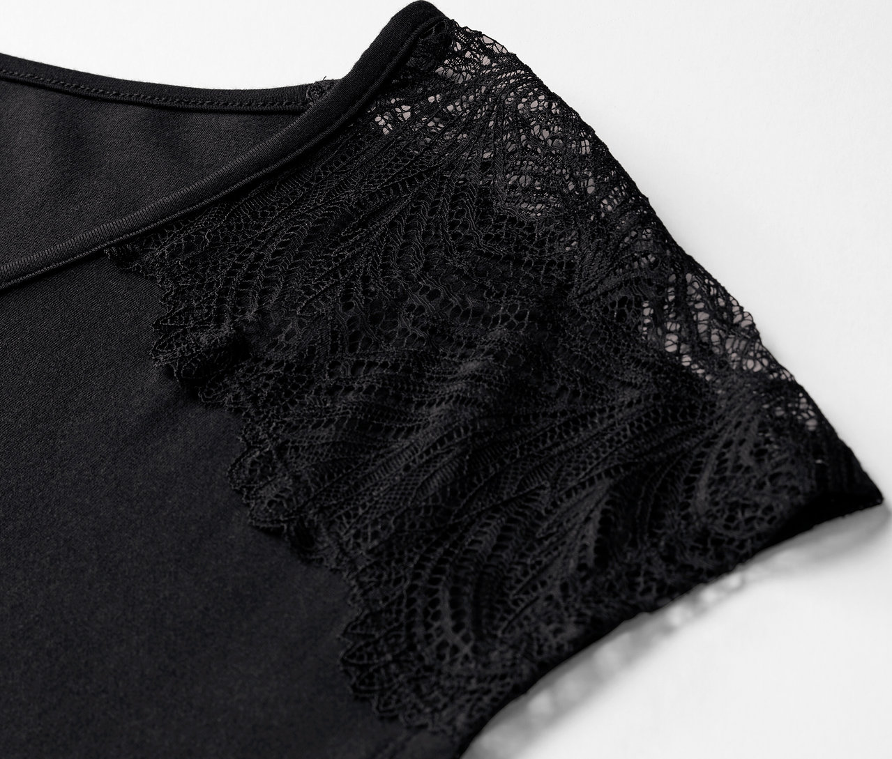 Detail čierneho krátkeho pyžamy s čipkovaným rukávom.
