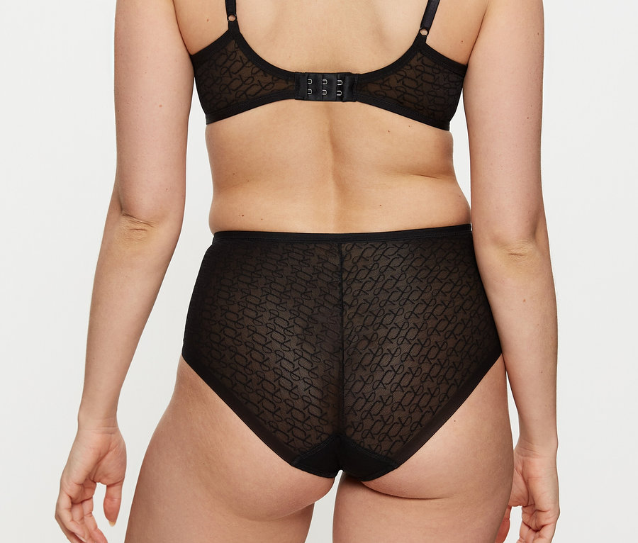 Žena zozadu v čiernej, vzorovanej podprsenke a čiernych, priesvitných nohavičkách Triumph Signature Sheer Maxi EX so vzorom.