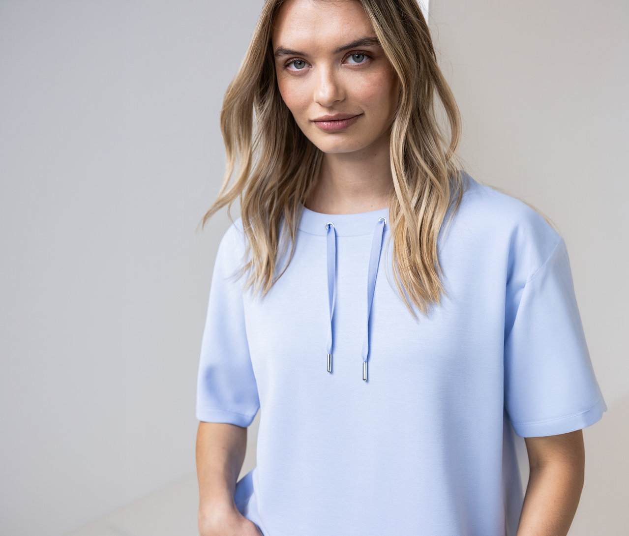 Žena má na sebe svetlomodré tričko Street One so šnúrkami pri výstrihu.