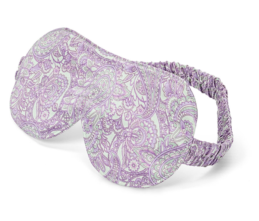 Detail záberu fialovej masky na spanie s bielym vzorom paisley.