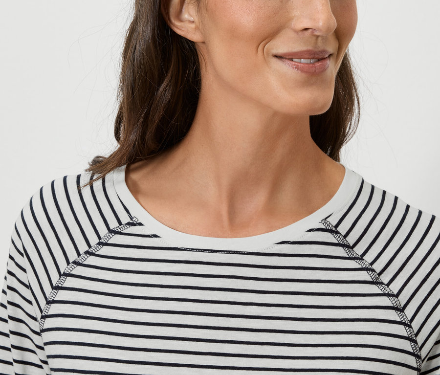 Detailný záber ženy v pruhovanom tričku s dlhým rukávom.