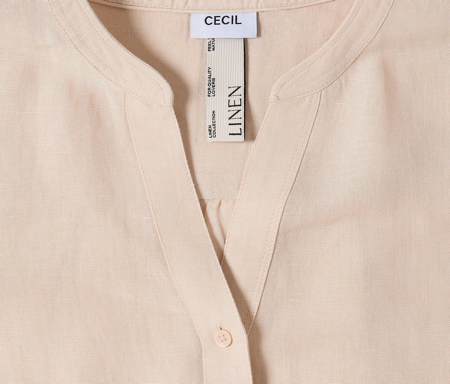 Detail svetlej ľanovej košele s gombíkom a štítkom CECIL.